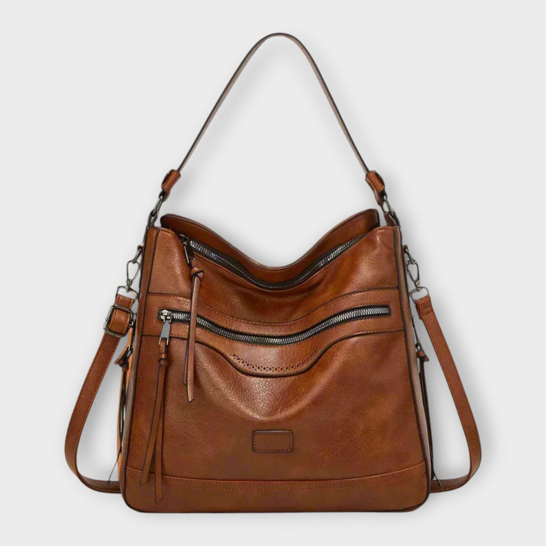 Dettaglio della texture e delle finiture della borsa a tracolla Amélie, colore marrone, con cuciture precise.