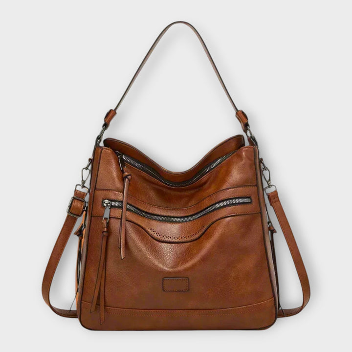 Dettaglio della texture e delle finiture della borsa a tracolla Amélie, colore marrone, con cuciture precise.