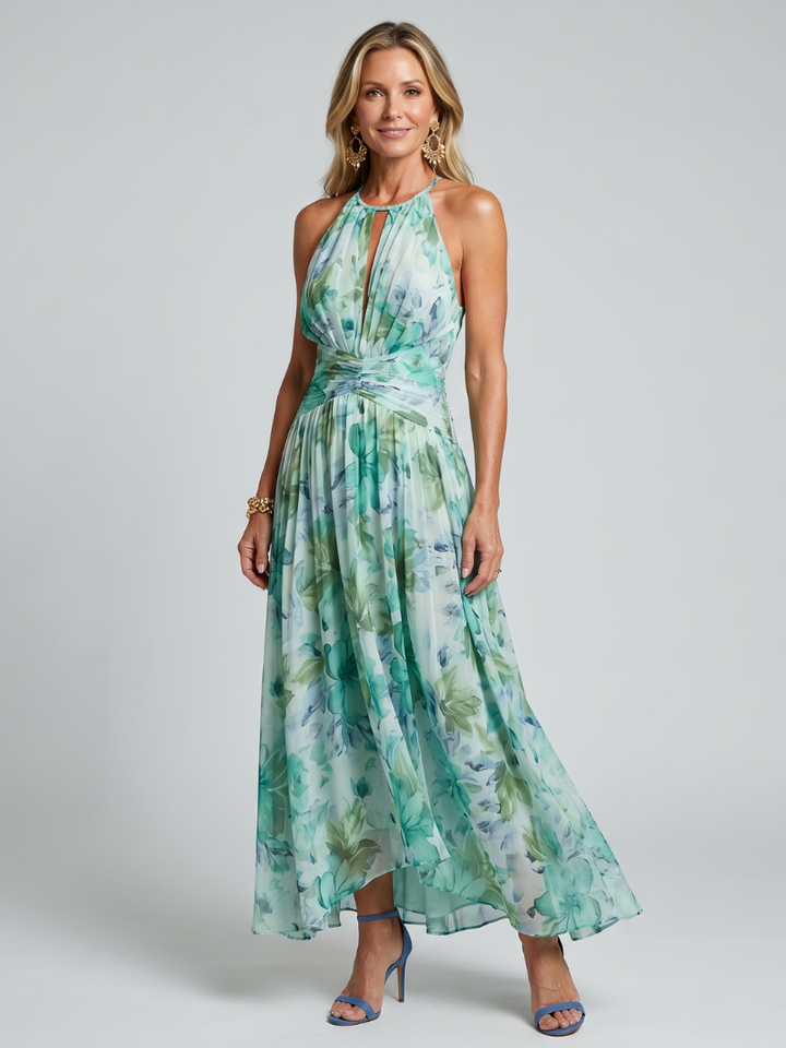 Modella che indossa un abito midi floreale plissettato verde con scollo all'americana, in una posa frontale che esalta il movimento del tessuto.