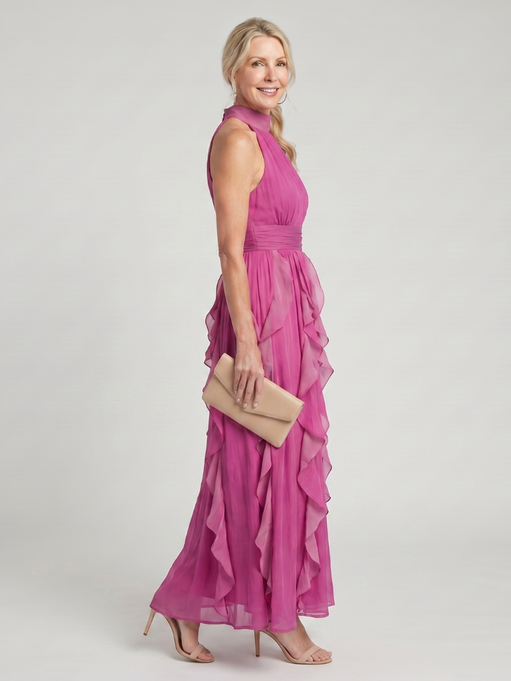 Modella che indossa l'abito elegante Anthea in un ambiente esterno, mostrando la lunghezza maxi e la vita definita.