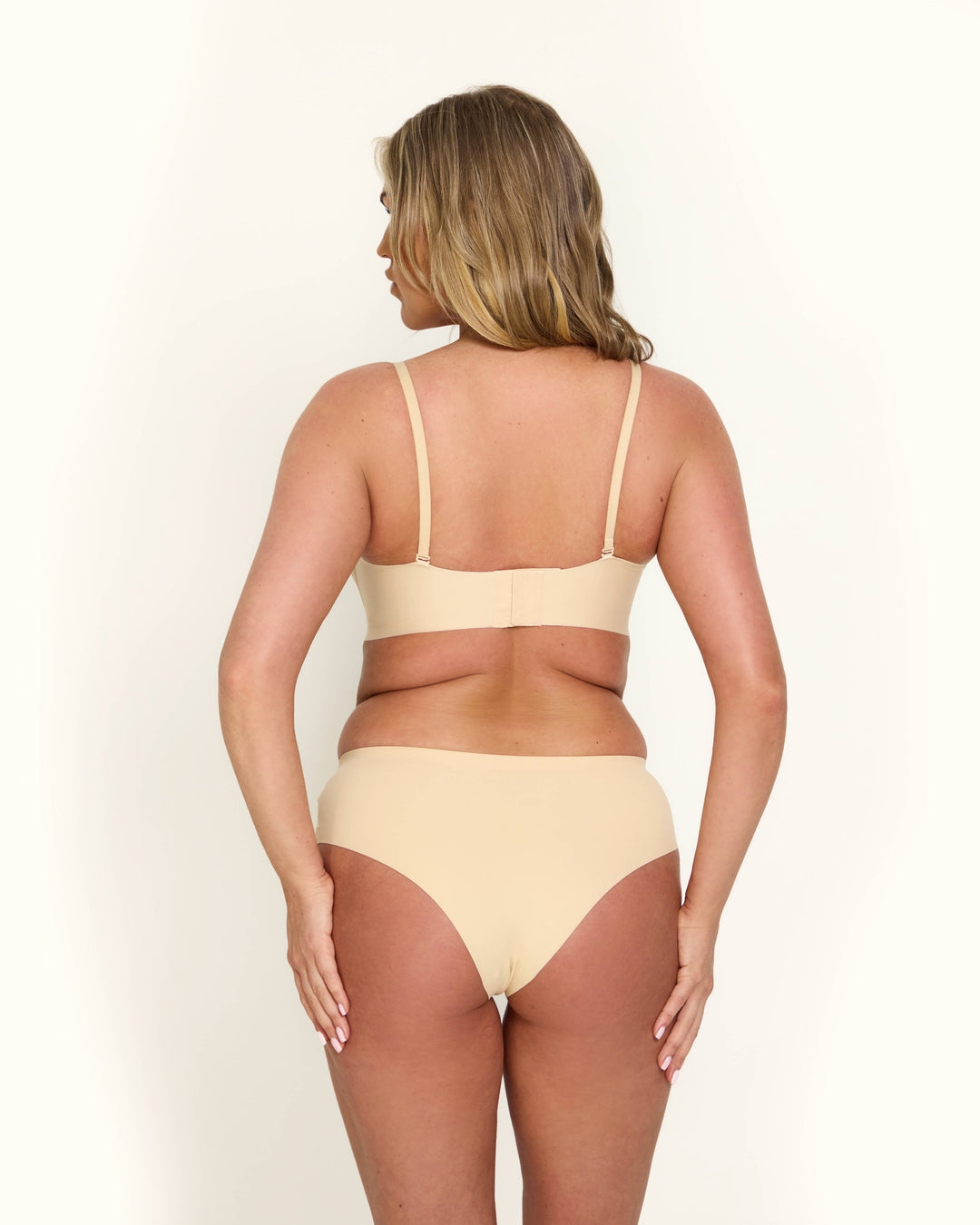 Il reggiseno invisibile push-up Antonia nero indossato sotto un top scollato, dimostrando il supporto discreto.
