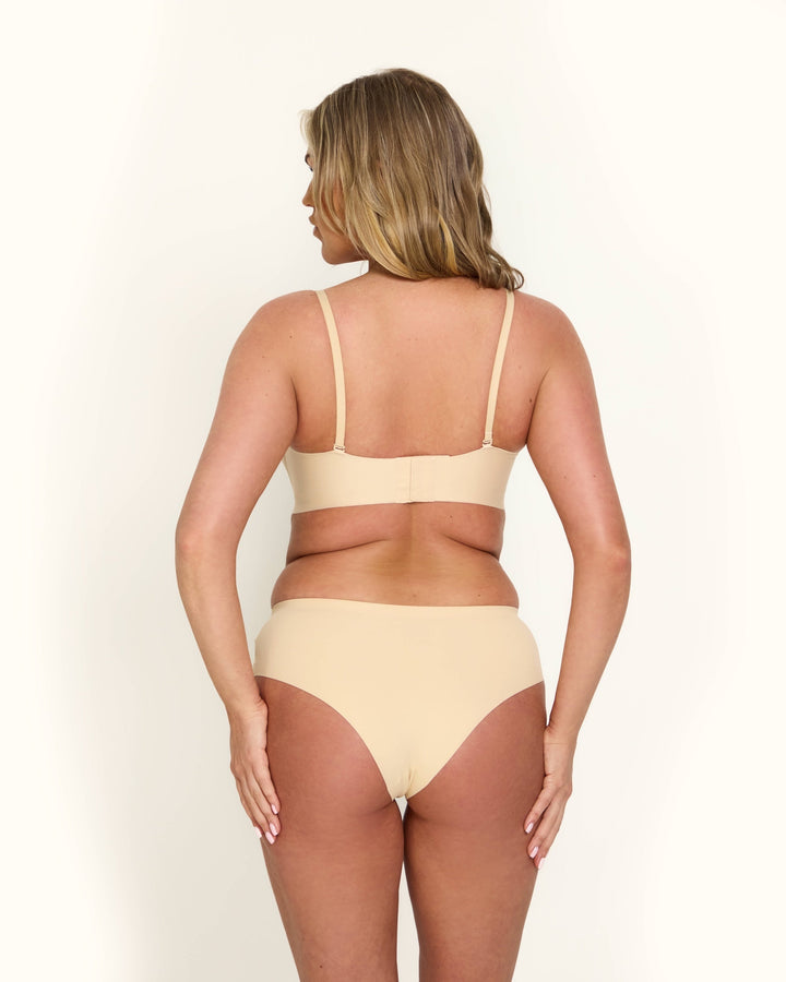 Il reggiseno invisibile push-up Antonia nero indossato sotto un top scollato, dimostrando il supporto discreto.