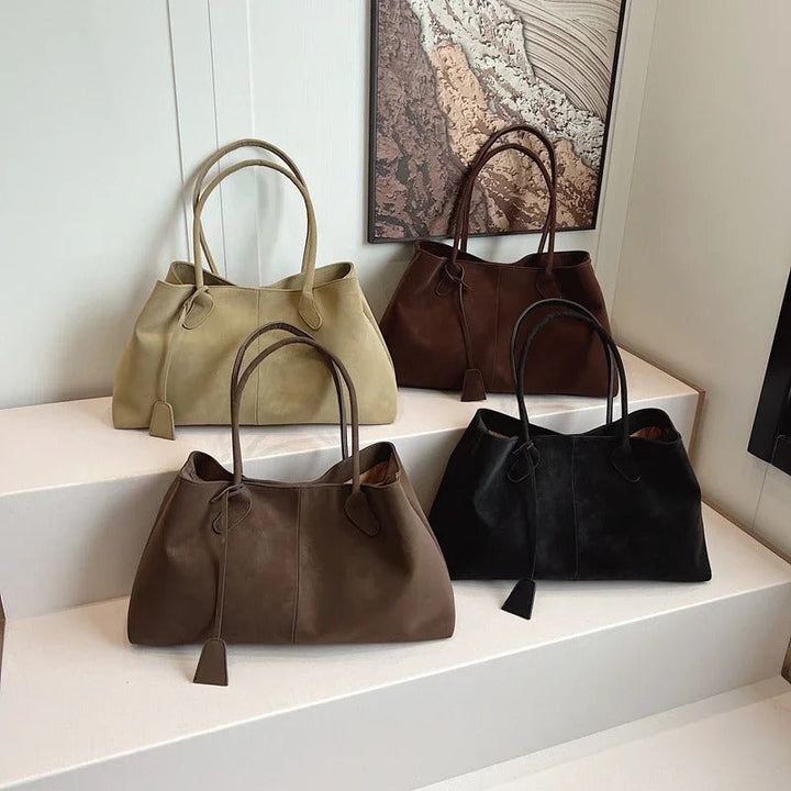 Donna che cammina con la borsa tote Arianna marrone scuro, catturando il movimento e la fluidità del design.