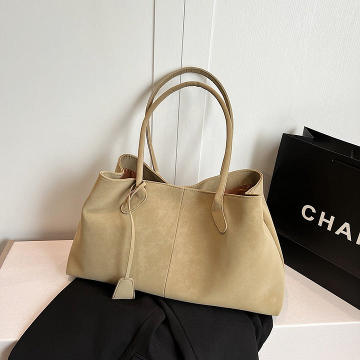 Donna che indossa la borsa tote Arianna color crema a spalla, in un contesto urbano e moderno.