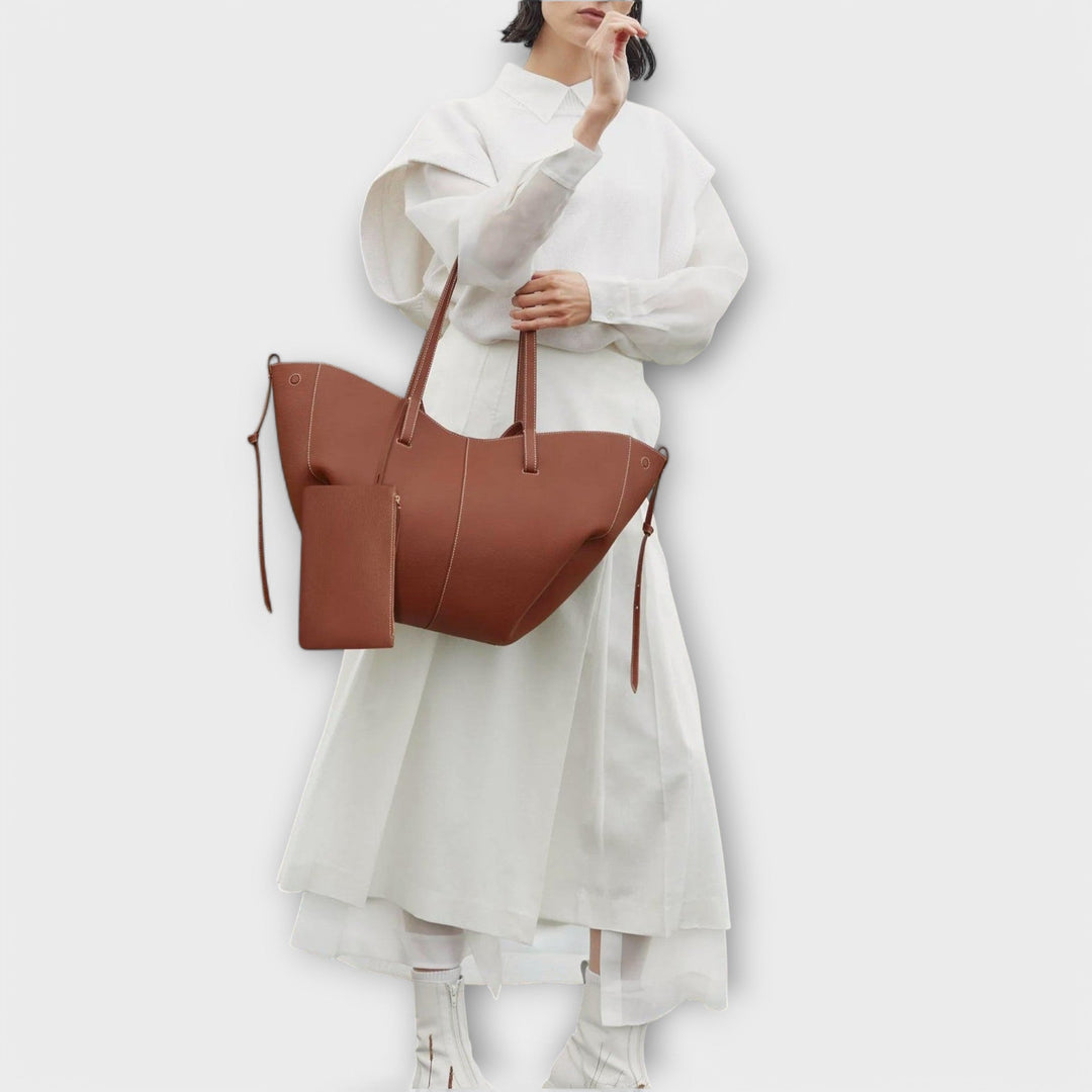 Borsa Aura grigia, in una composizione lifestyle con accessori di moda.
