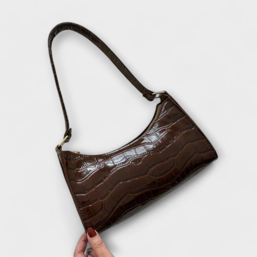 La borsa Bianca verde in una composizione con altri accessori, suggerendo un look completo.