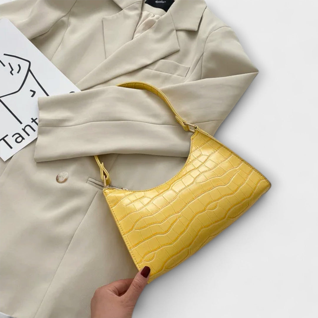 Modella che tiene la borsa Bianca beige, mostrando come si adatta a un abbigliamento casual chic.