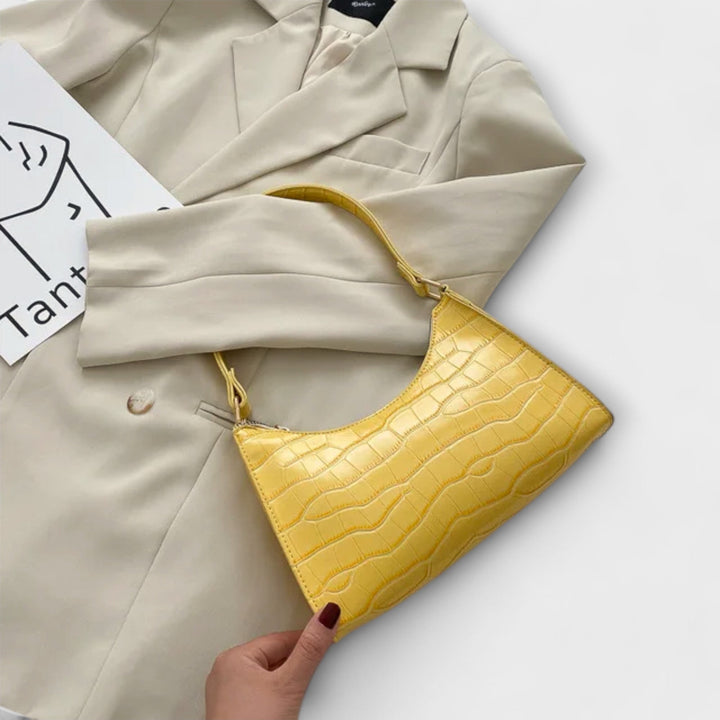 Modella che tiene la borsa Bianca beige, mostrando come si adatta a un abbigliamento casual chic.