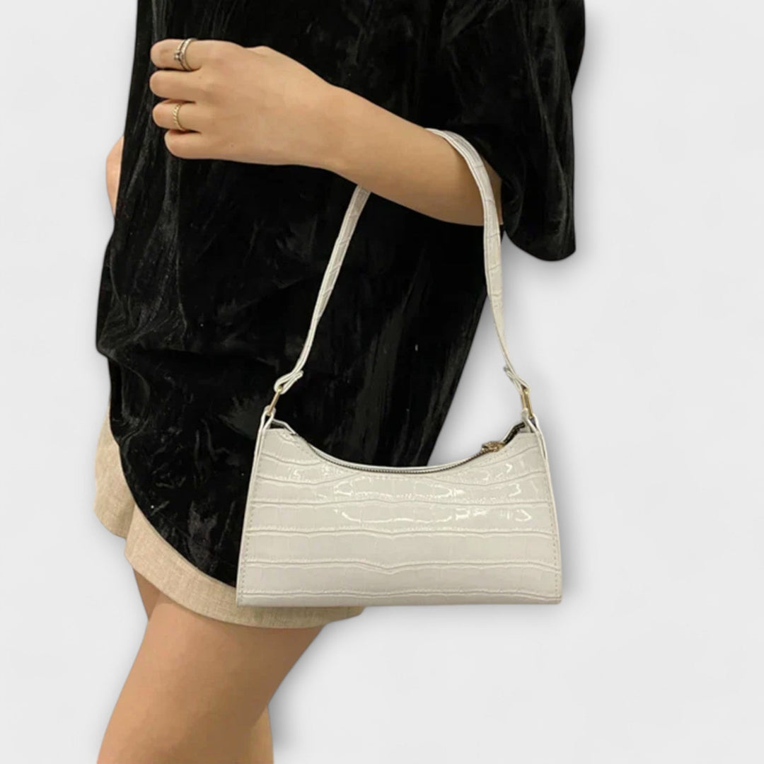 Dettaglio della chiusura e dei manici della borsa Bianca beige, con un focus sulla qualità delle cuciture.