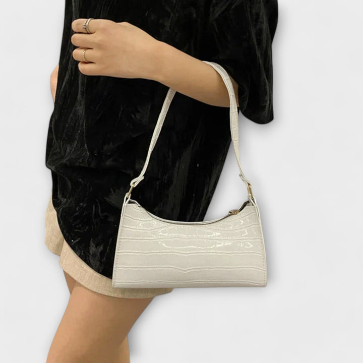 Dettaglio della chiusura e dei manici della borsa Bianca beige, con un focus sulla qualità delle cuciture.