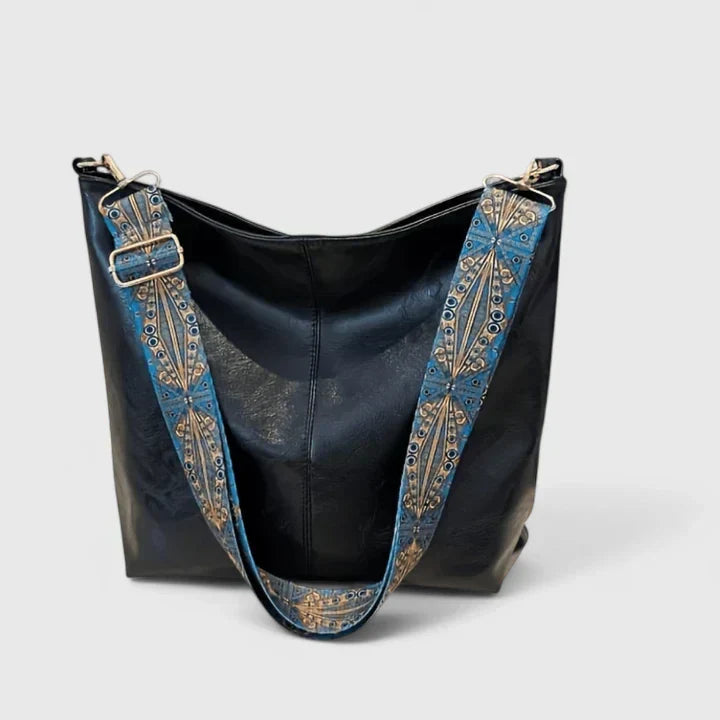 Donna che indossa la borsa Bianca nera come borsa a tracolla, in un contesto urbano elegante.