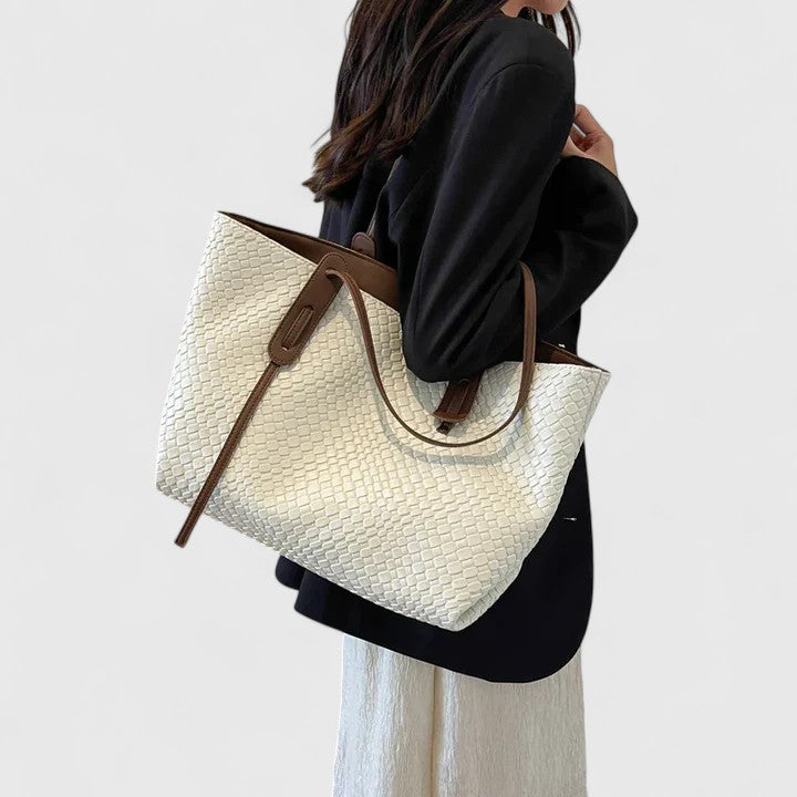 Borsa elegante intrecciata Calliope in colore kaki, vista laterale con i manici in evidenza.