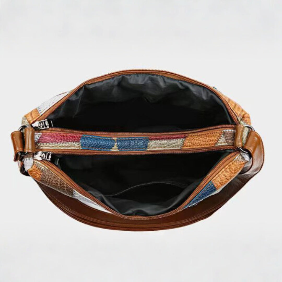 Una donna che tiene la borsa a spalla Camille in mano, mostrando la sua versatilità d'uso.