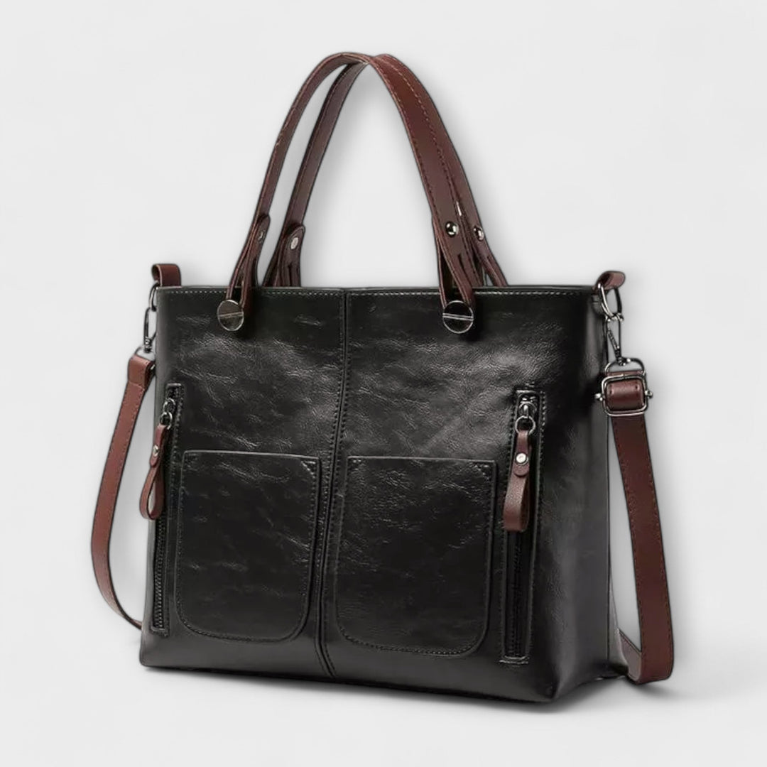 Borsa Cassia in pelle grigia, vista posteriore, con un piccolo scomparto esterno, perfetta per un accesso rapido.