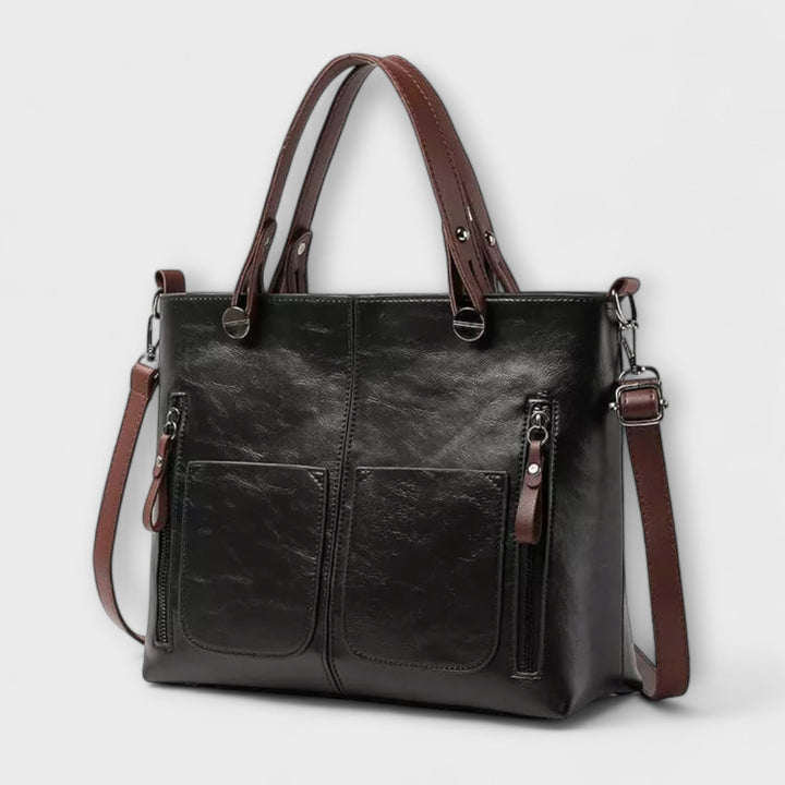 Borsa Cassia in pelle grigia, vista posteriore, con un piccolo scomparto esterno, perfetta per un accesso rapido.