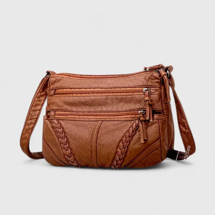 Primo piano della texture della pelle della borsa Clara, che evidenzia la qualità del materiale.