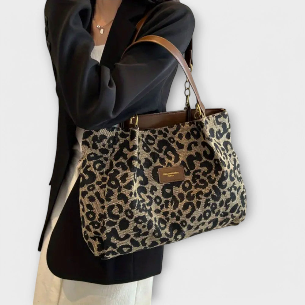 Borsa leopardata Clelia in una prospettiva ravvicinata che mostra la texture del tessuto e le cuciture dei manici, con dettagli interni leggermente visibili.