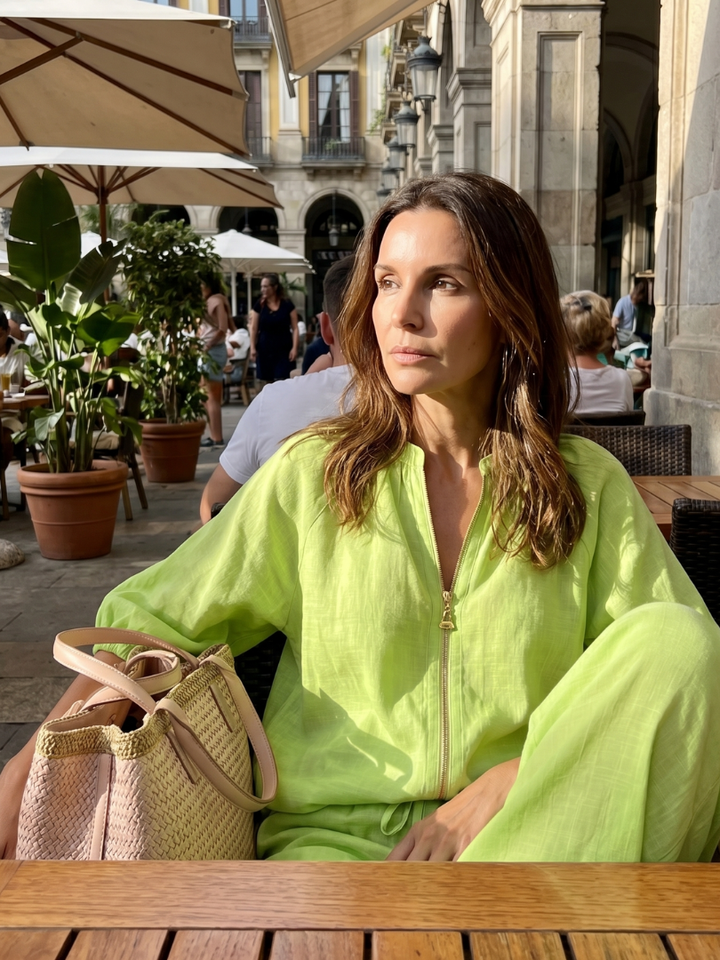 Modella che indossa pantaloni a gamba larga Cleo bianchi, con un sorriso naturale.