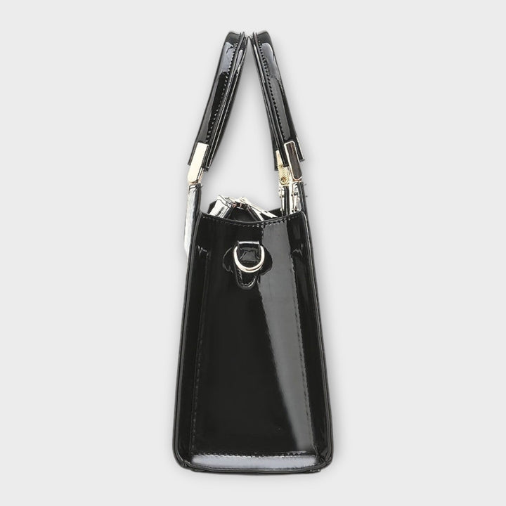 Borsa con motivo coccodrillo lucido di colore marrone, portata a spalla da una modella in ambiente urbano.