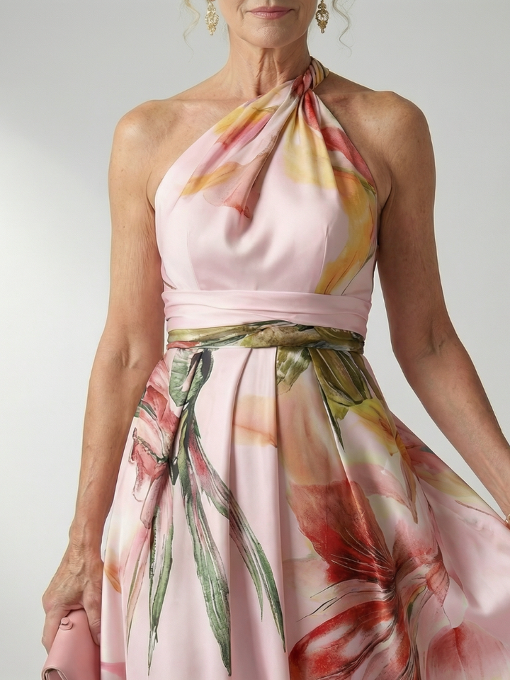 Volledig vooraanzicht van de Elara licht bloemen maxi-jurk in paarse tinten, gedragen door een model in een natuurlijke setting.