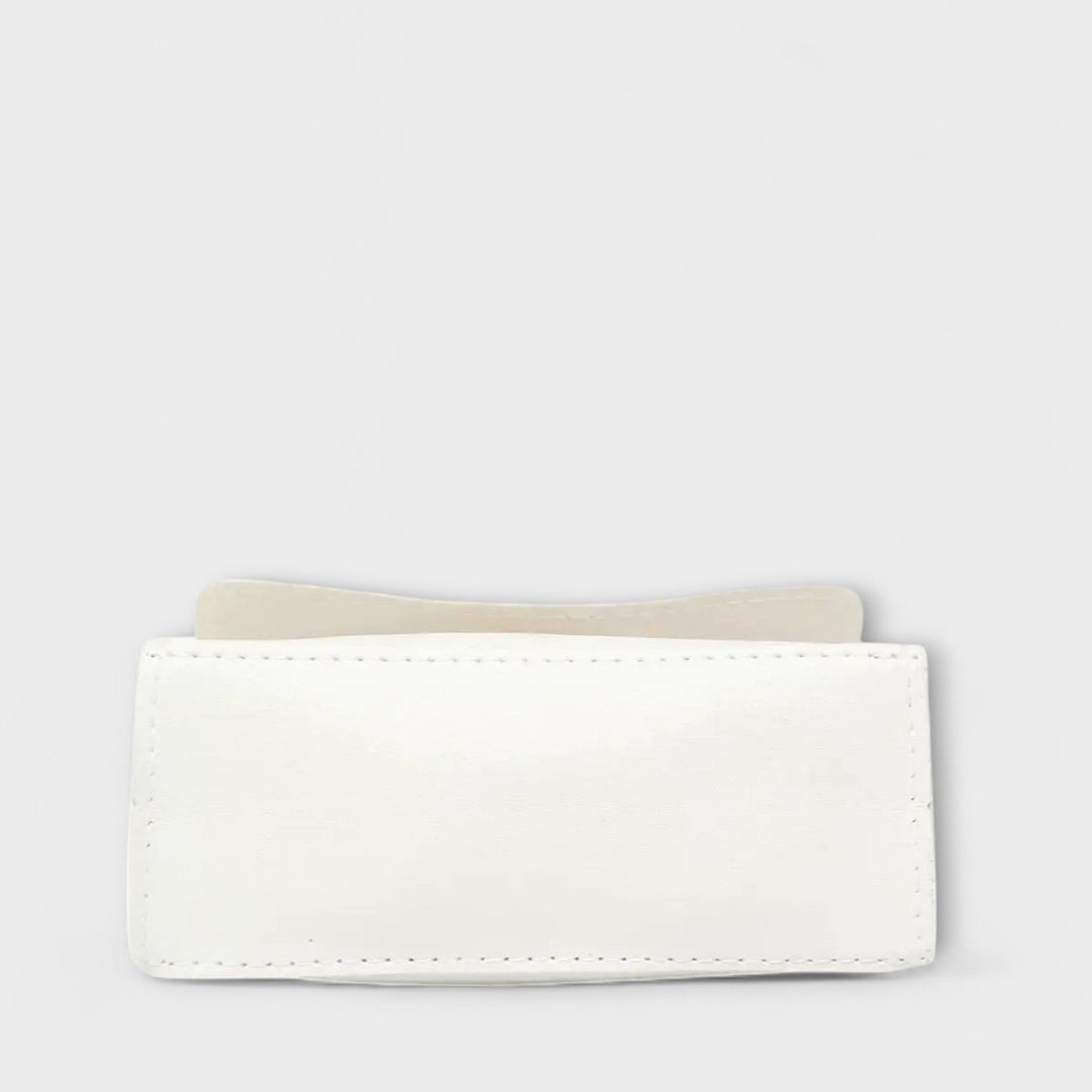 Borsa a spalla Eleonora, variante colore nero, su un tavolo in legno con sfondo sfocato.