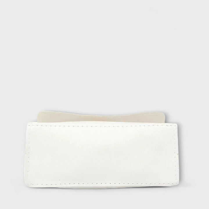 Borsa a spalla Eleonora, variante colore nero, su un tavolo in legno con sfondo sfocato.
