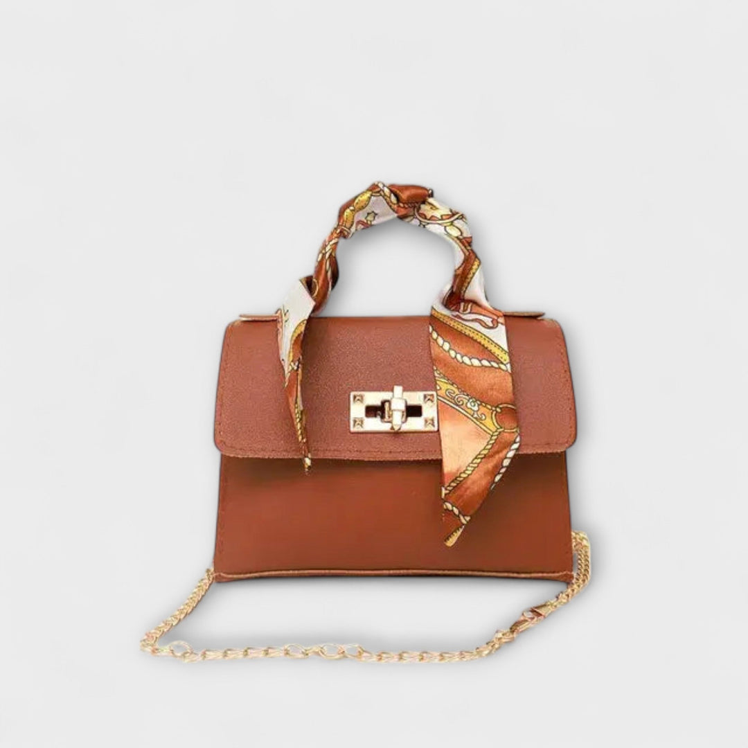 Borsa a spalla Eleonora in una composizione con altri accessori, enfatizzando la versatilità.