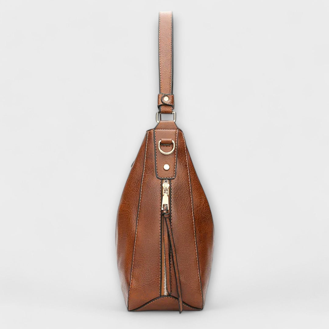 Borsa a tracolla Elina indossata da una donna in un contesto urbano, dimostrando la sua vestibilità e il suo stile moderno.