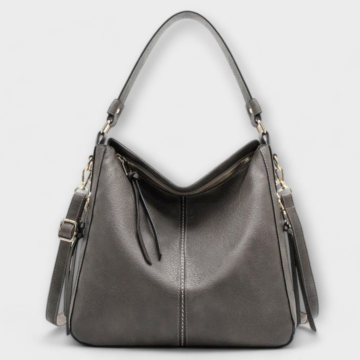 Borsa Elina di colore marrone, con attenzione ai dettagli delle finiture e alla morbidezza del materiale, su sfondo chiaro.