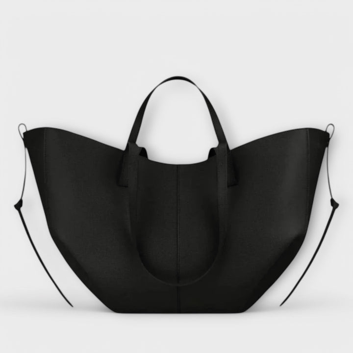 Borsa Ella nera indossata a spalla da una modella, in un contesto urbano, evidenziando la sua versatilità.