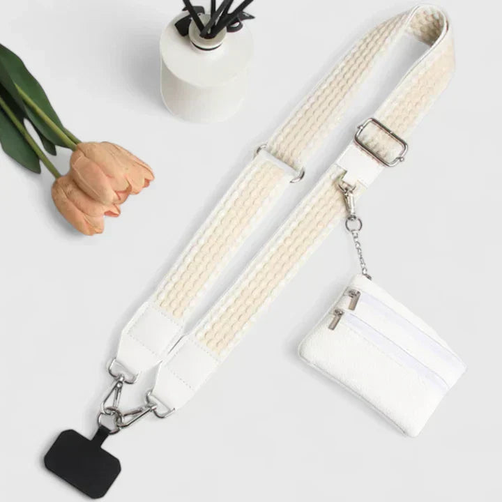 Donna che tiene la borsa Elodie nera e bianca al polso, in una posa elegante, mostrando l'opzione cinturino.