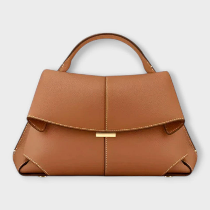 Borsa a tracolla di lusso bordeaux, indossata su una spalla, con una donna in un contesto urbano che ne mostra la versatilità.