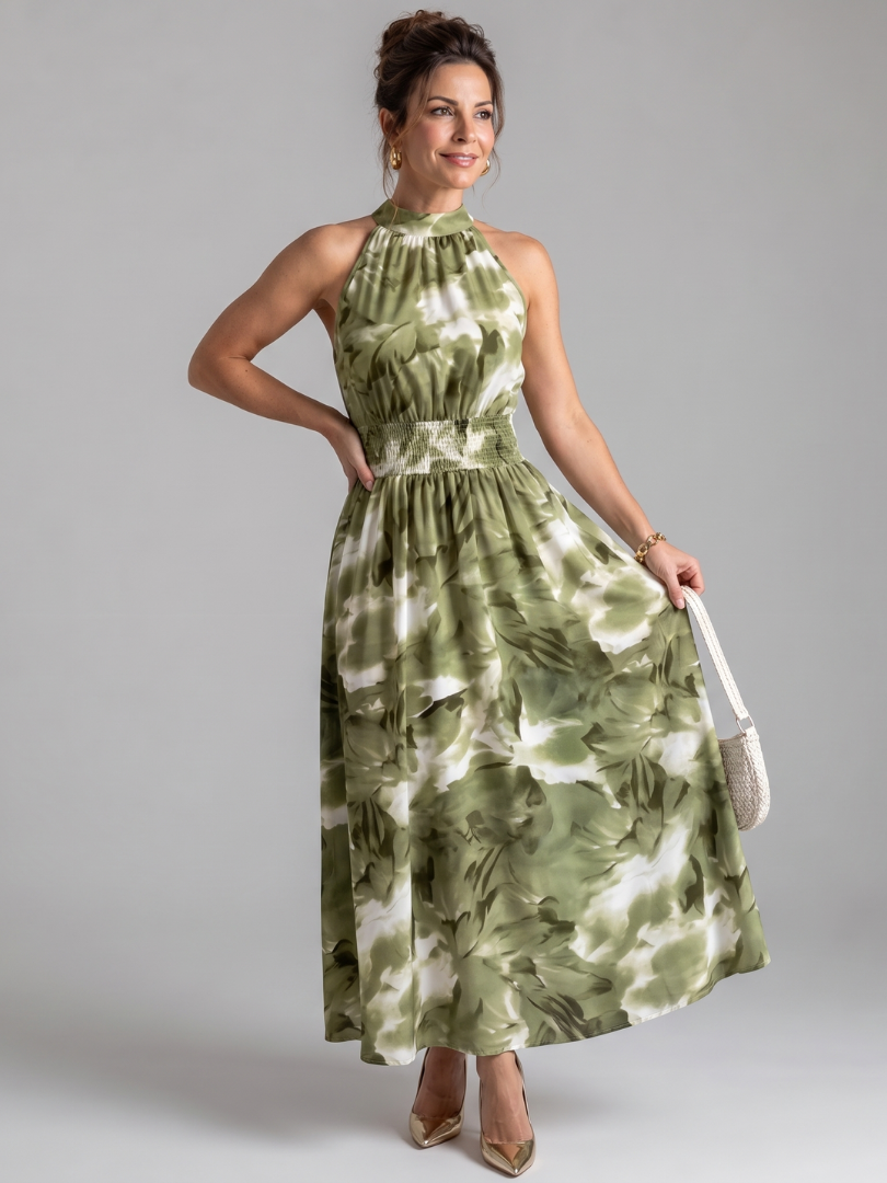Model toont de Fiora midi jurk in groen met abstracte print, volledig zichtbaar van voren.