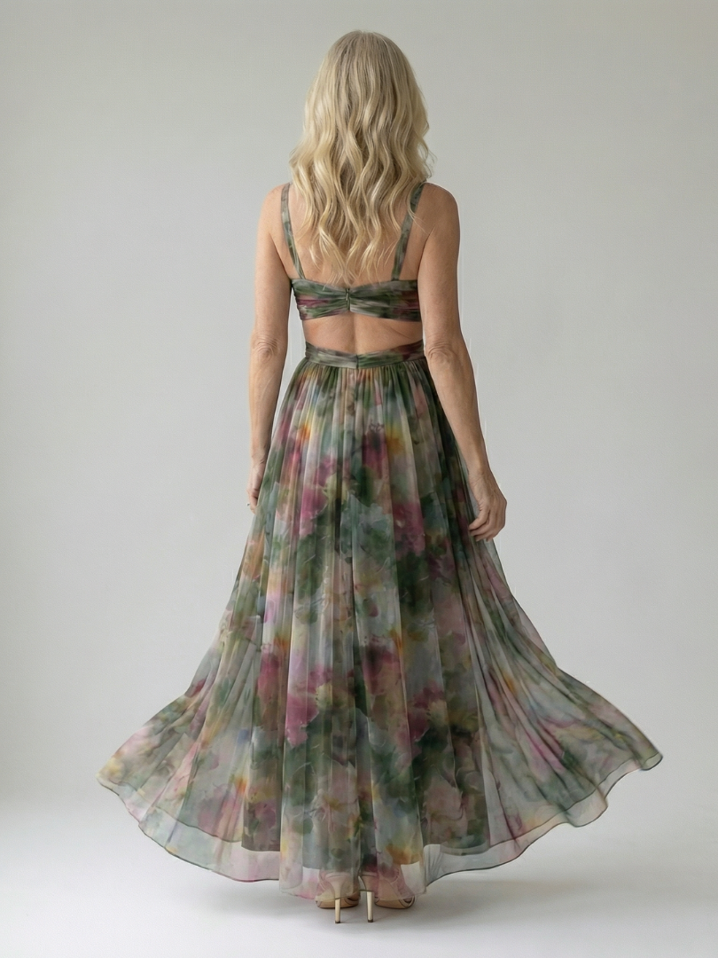 Model draagt de roze Fleur maxi wikkeljurk, met een accessoire dat de jurk aanvult, in een lifestyle setting.