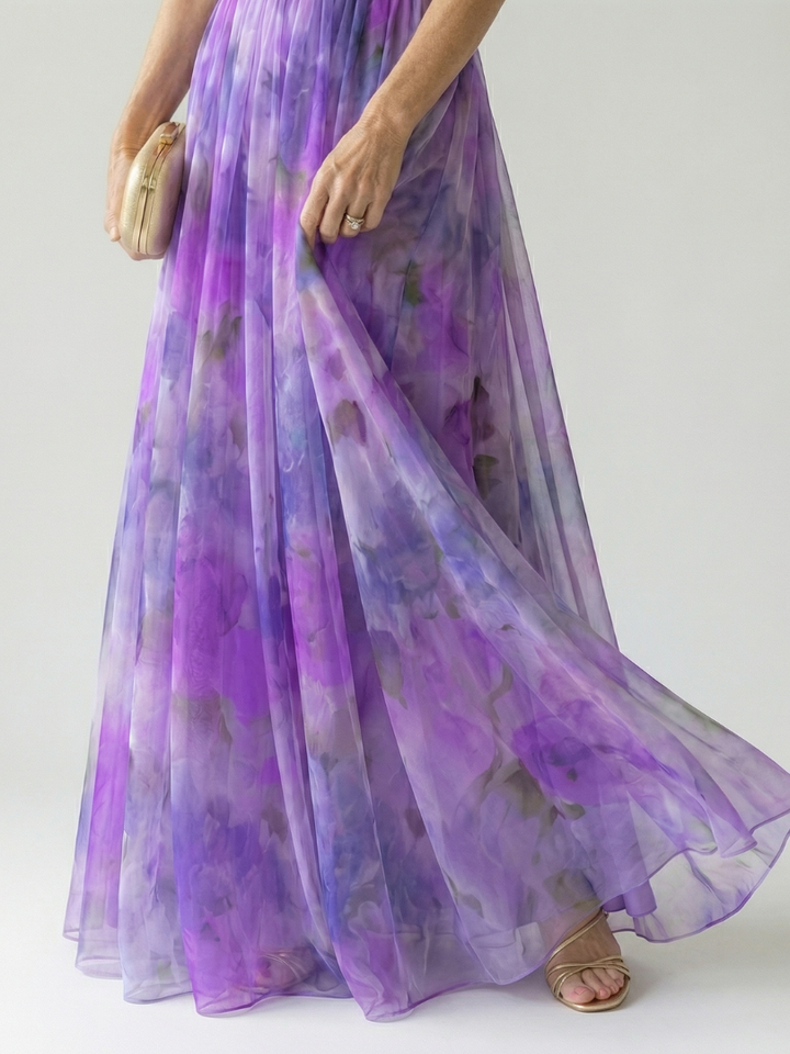 Model lachend en ontspannen in de veelkleurige Fleur maxi wikkeljurk, straalt zomerse vrolijkheid uit.
