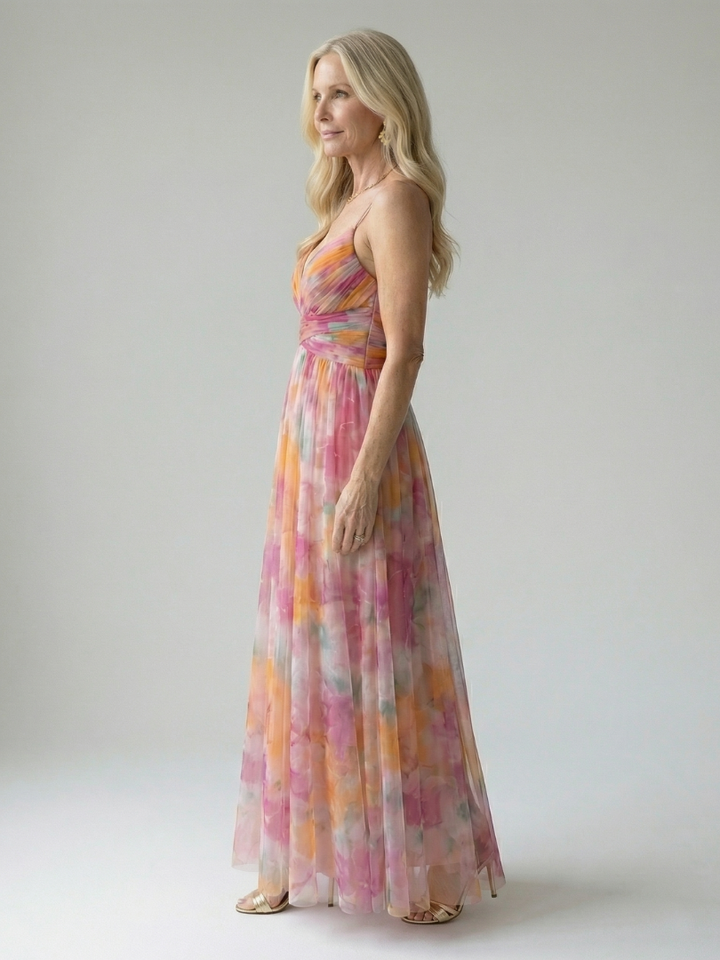 Zijaanzicht van de gele Fleur maxi wikkeljurk, die de soepele stof en de vloeiende lijn benadrukt.