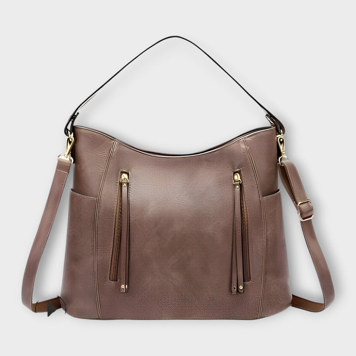 Borsa a mano Ginevra in colore nero, indossata a spalla da una donna in un contesto urbano elegante.