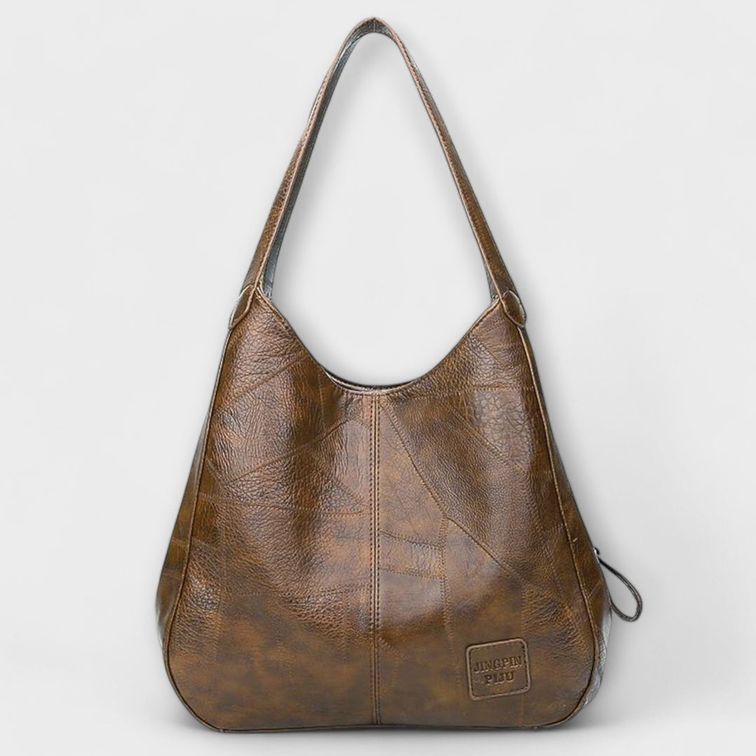 La borsa vintage Greta in un contesto di viaggio, posizionata elegantemente su un sedile, pronta per l'avventura.