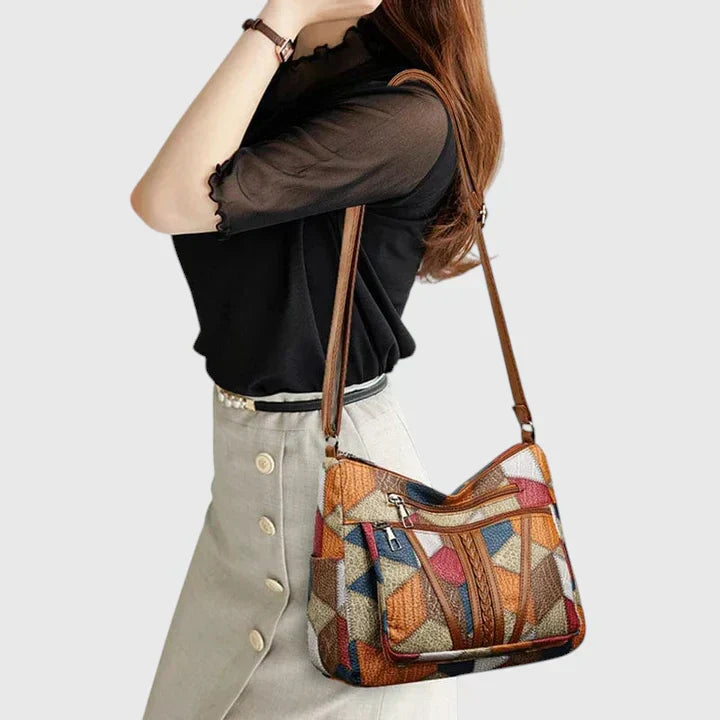 Interno della borsa Hadria, mostrando le tasche multiple con cerniera per l'organizzazione