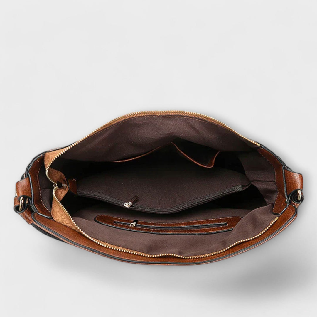 Borsa Indira rossa, posizionata su una scrivania, che mostra come possa essere un accessorio professionale e di tendenza.