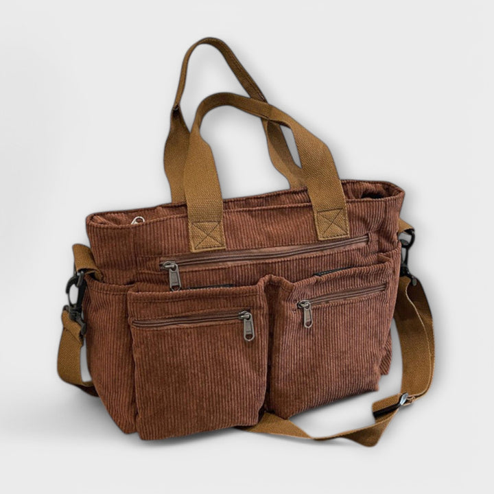 Borsa tote Iris beige, posizionata accanto a un laptop e un quaderno, suggerendo l'uso per l'ufficio.