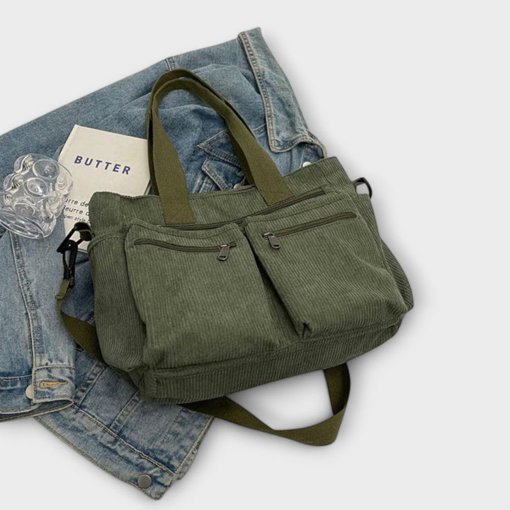 Dettaglio dell'etichetta interna della borsa tote Iris, con il logo e le istruzioni di cura.