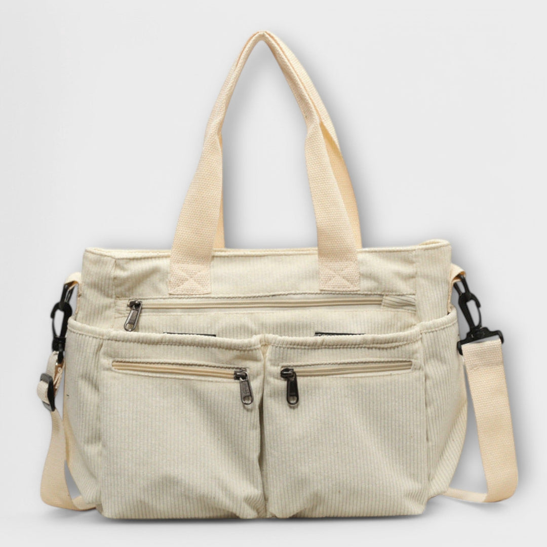 Borsa tote Iris beige, appoggiata su una superficie chiara, mettendo in risalto la texture del materiale.