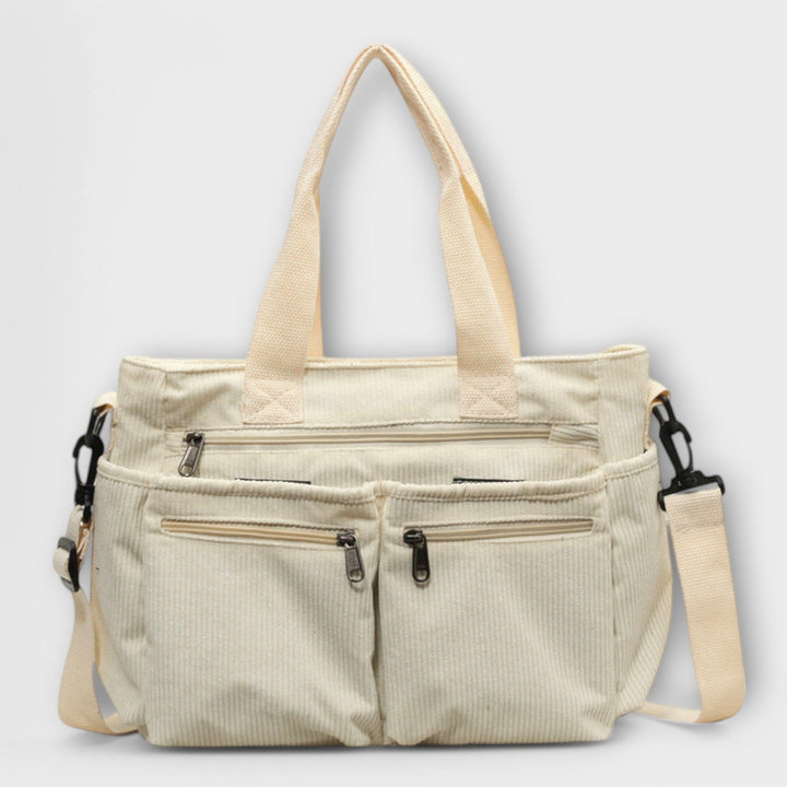 Borsa tote Iris beige, appoggiata su una superficie chiara, mettendo in risalto la texture del materiale.