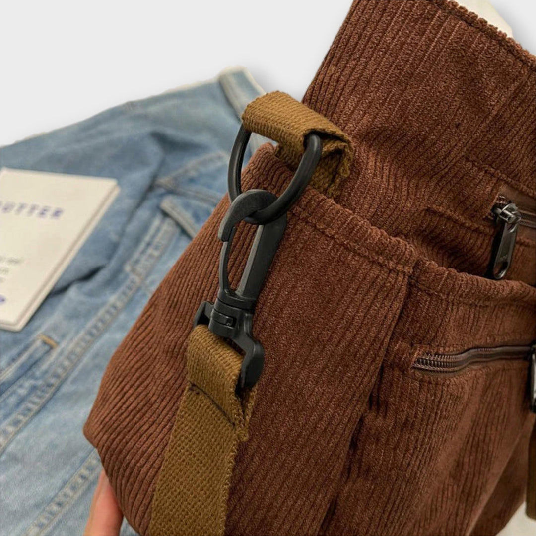 Donna che indossa la borsa tote Iris nera a spalla, in un contesto urbano, evidenziando la versatilità.