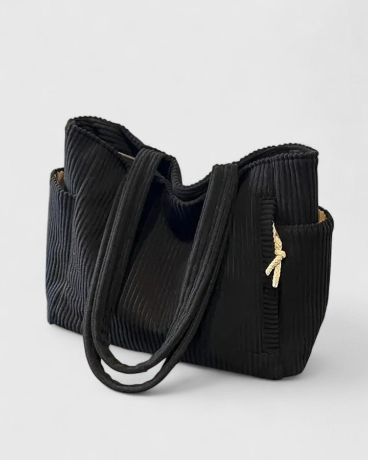 Borsa Isabel nera, mostrata di lato per evidenziare le tasche esterne e la silhouette elegante.