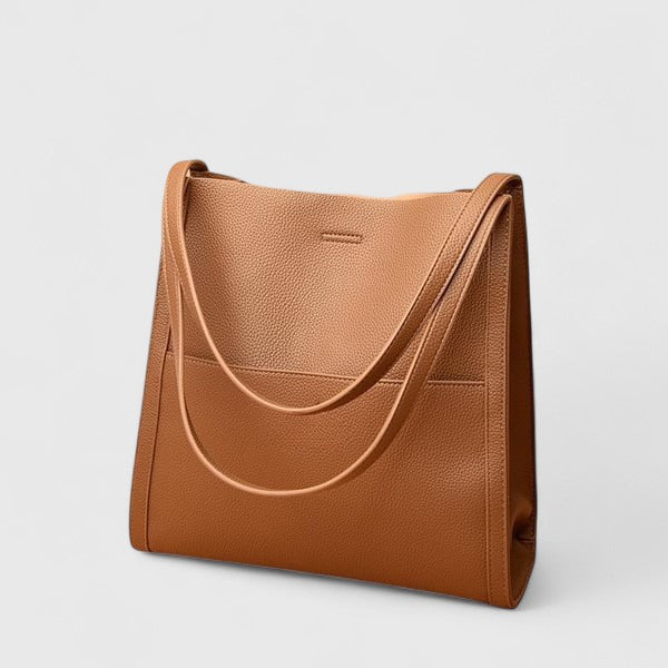 Borsa a spalla Isabella nera indossata da una donna in ambiente urbano, mostrando la sua versatilità e stile.