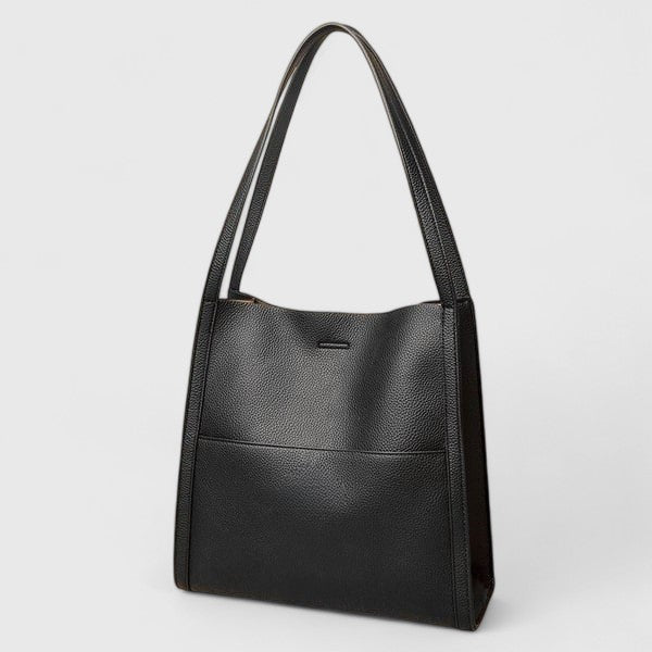 Borsa a spalla Isabella grigia posta su una superficie elegante, evidenziando la texture e la forma strutturata.