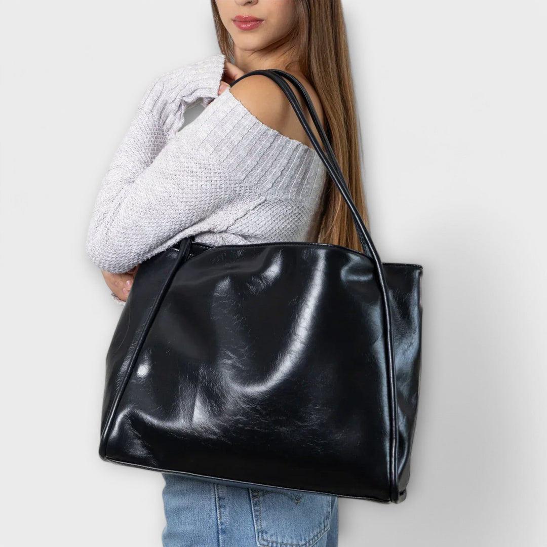 Borsa tote Isabelle rossa, posizionata in un ambiente urbano, con focus sui dettagli delle cuciture.