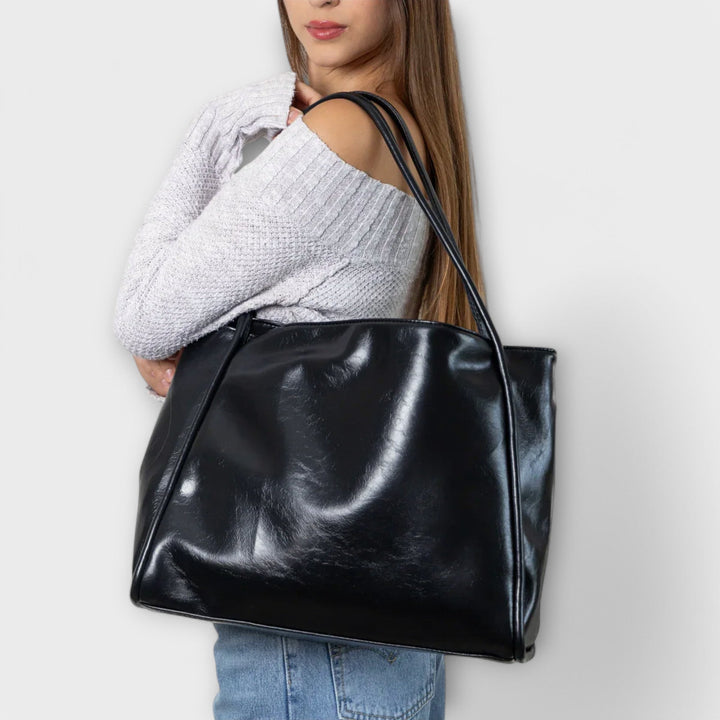 Borsa tote Isabelle rossa, posizionata in un ambiente urbano, con focus sui dettagli delle cuciture.